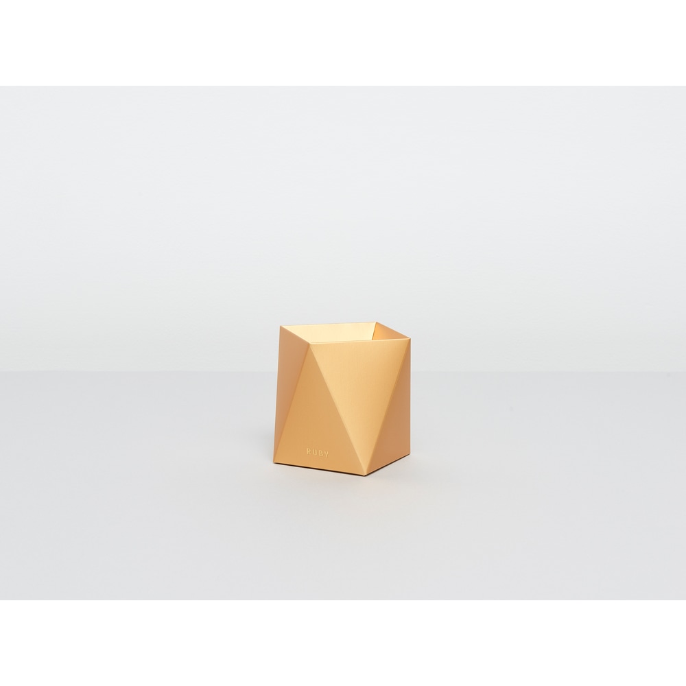 Goldene Ruby Papiervase auf einem grauweissen Tisch.