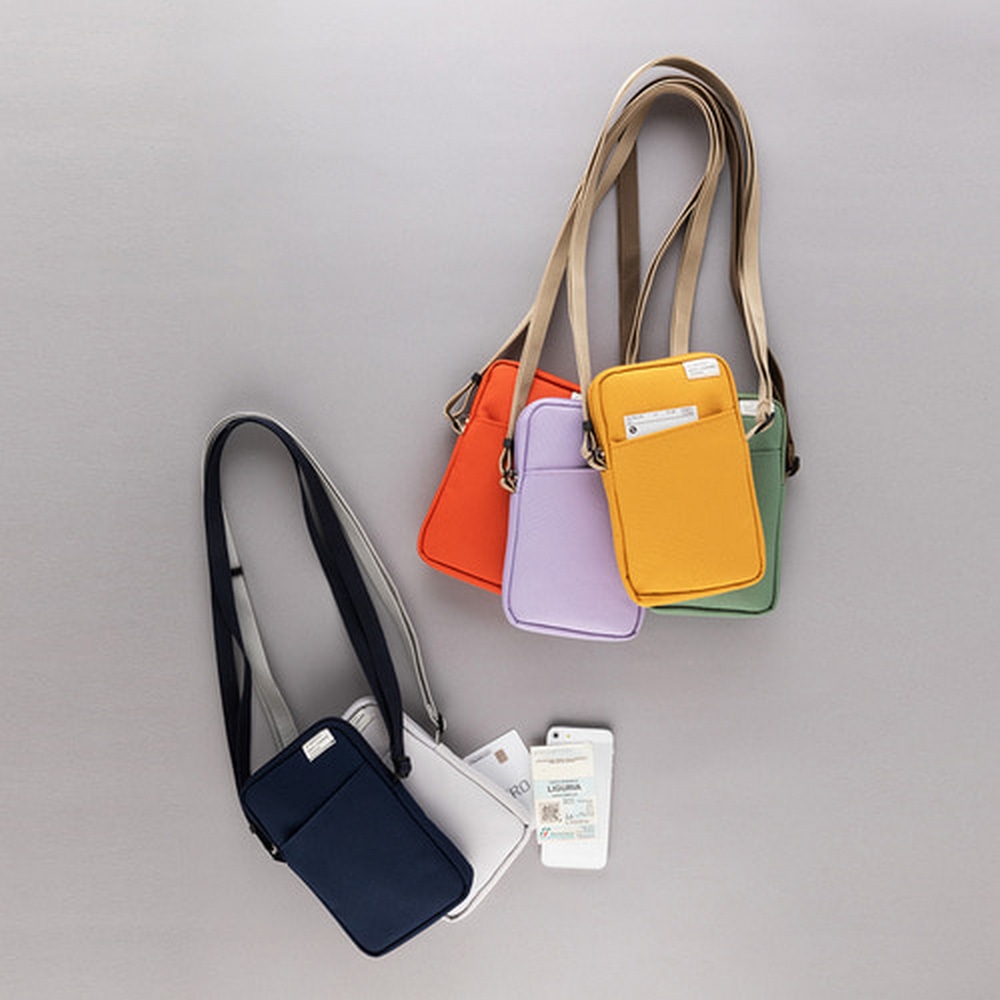 Alle Farbversionen des Cordura Pocket Mobile Bag haengen an einem Haken an der Wand.