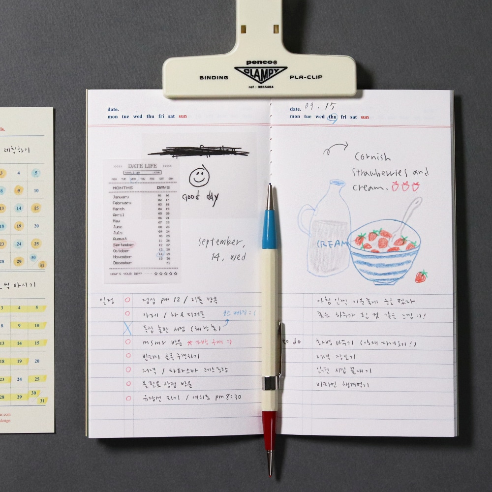 Innenseite fuer Notizen im Signature Planner Daily mit Zeichnungen und Text. Auf dem Planer eine weisse Klammer und ein Stift.
