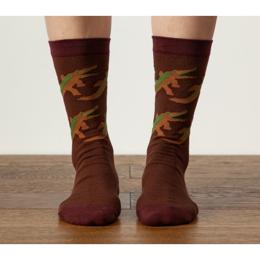 Fuesse in Warmgreytail Socken Crocodile Brown auf Holzboden von vorne.