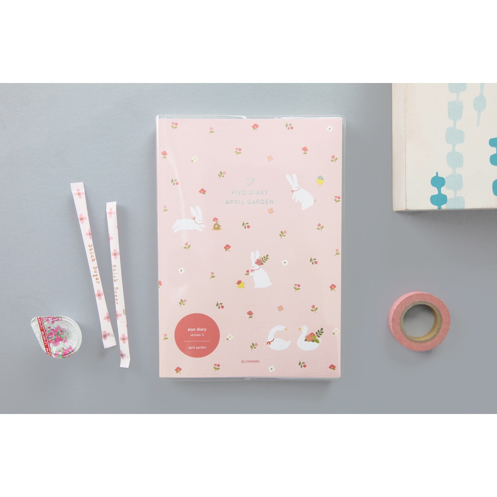 Piyo April Garden Pink, Jahresplaner ohne Datum, neben Maskingtape und Suessigkeiten.
