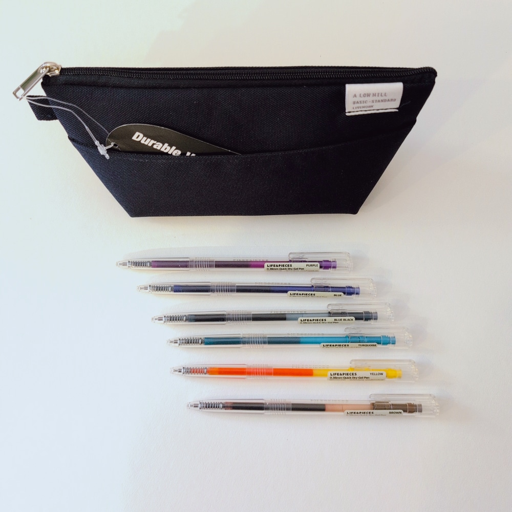 Pen pouch Cordura in Navy steht hinter schoen aufgereihten Stiften mit farbigen Gelminen.