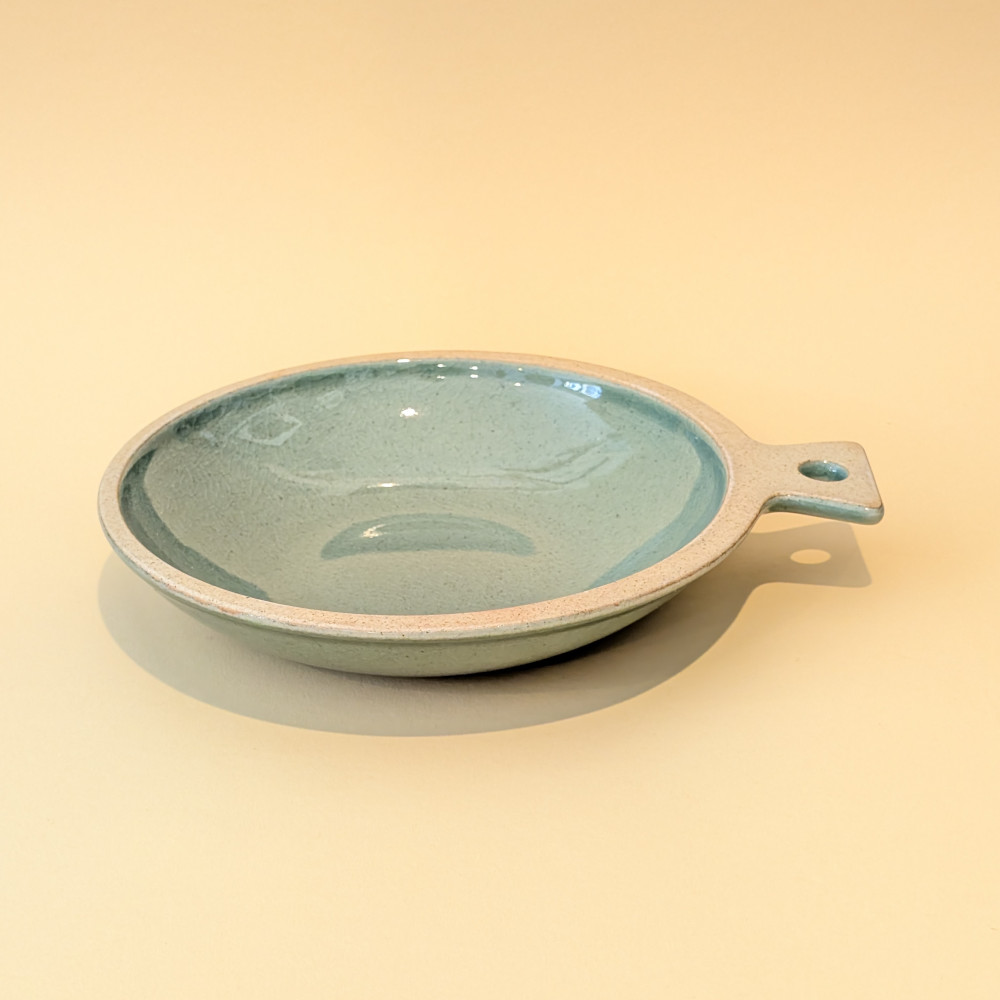 Sonjabi Fish Plate Large, eine kreisrunde Schale in Form eines Fisches, mit Handgriff und leuchtend gruener Glasur