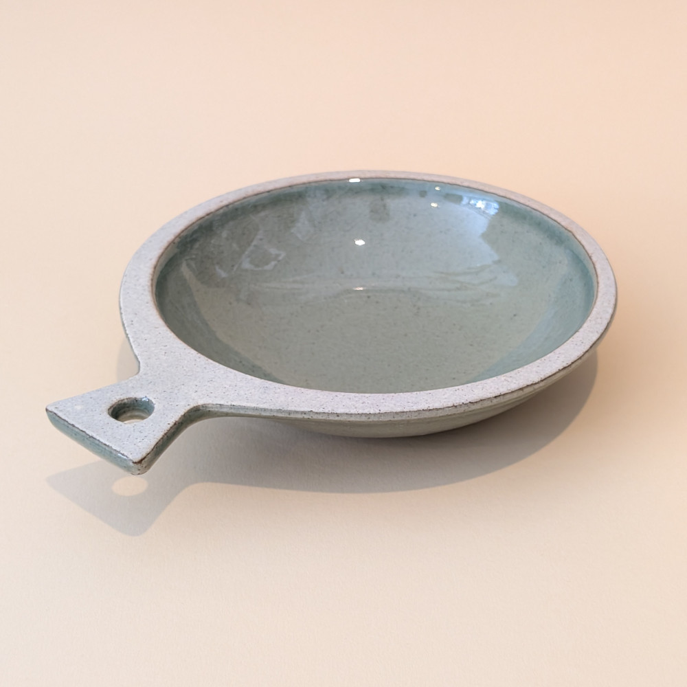 Gruene Sonjabi Fish Plate Large, eine kreisrunde Schale oder Anrichtplatte in Form eines Fisches, mit Handgriff und gruener Glasur.